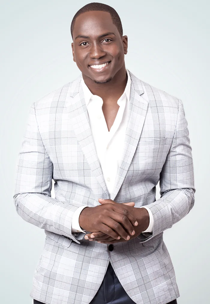 Marcus in a light plaid suit against a soft studio background
