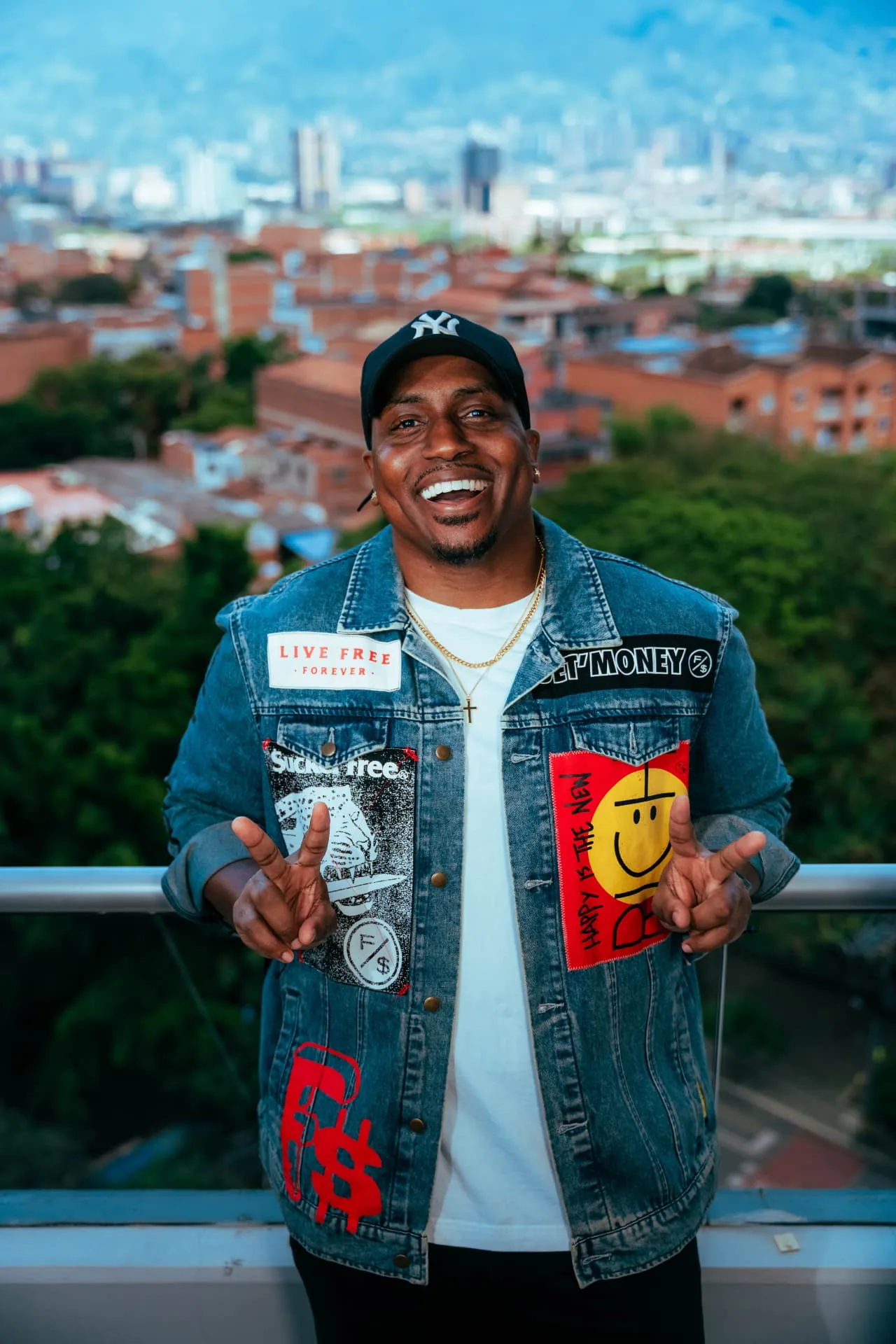 Marcus Majors in a patched denim jacket above the Medellín skyline