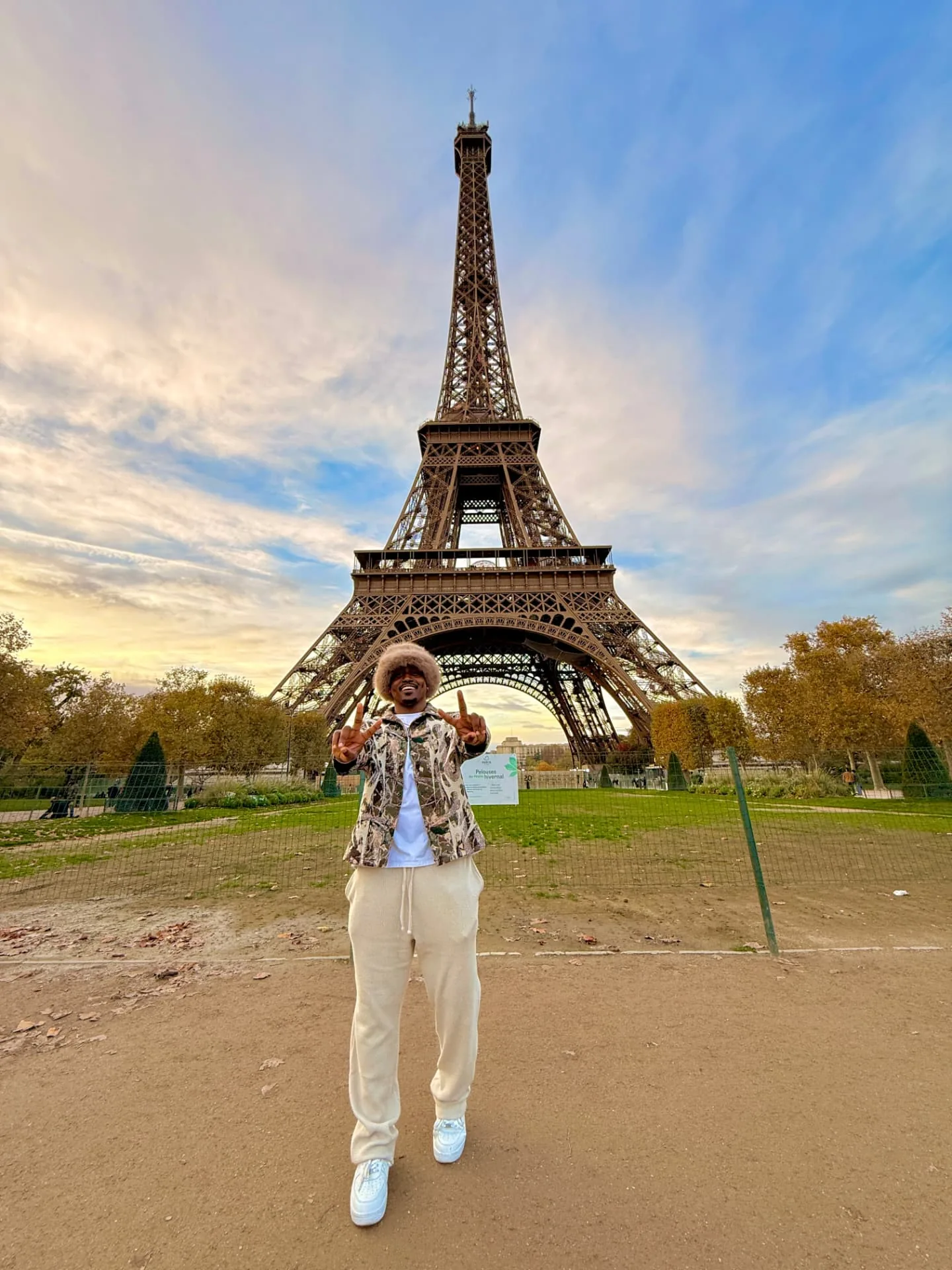 Marcus flashing peace signs in front of the Eiffel Tower at Champ de Mars in Paris