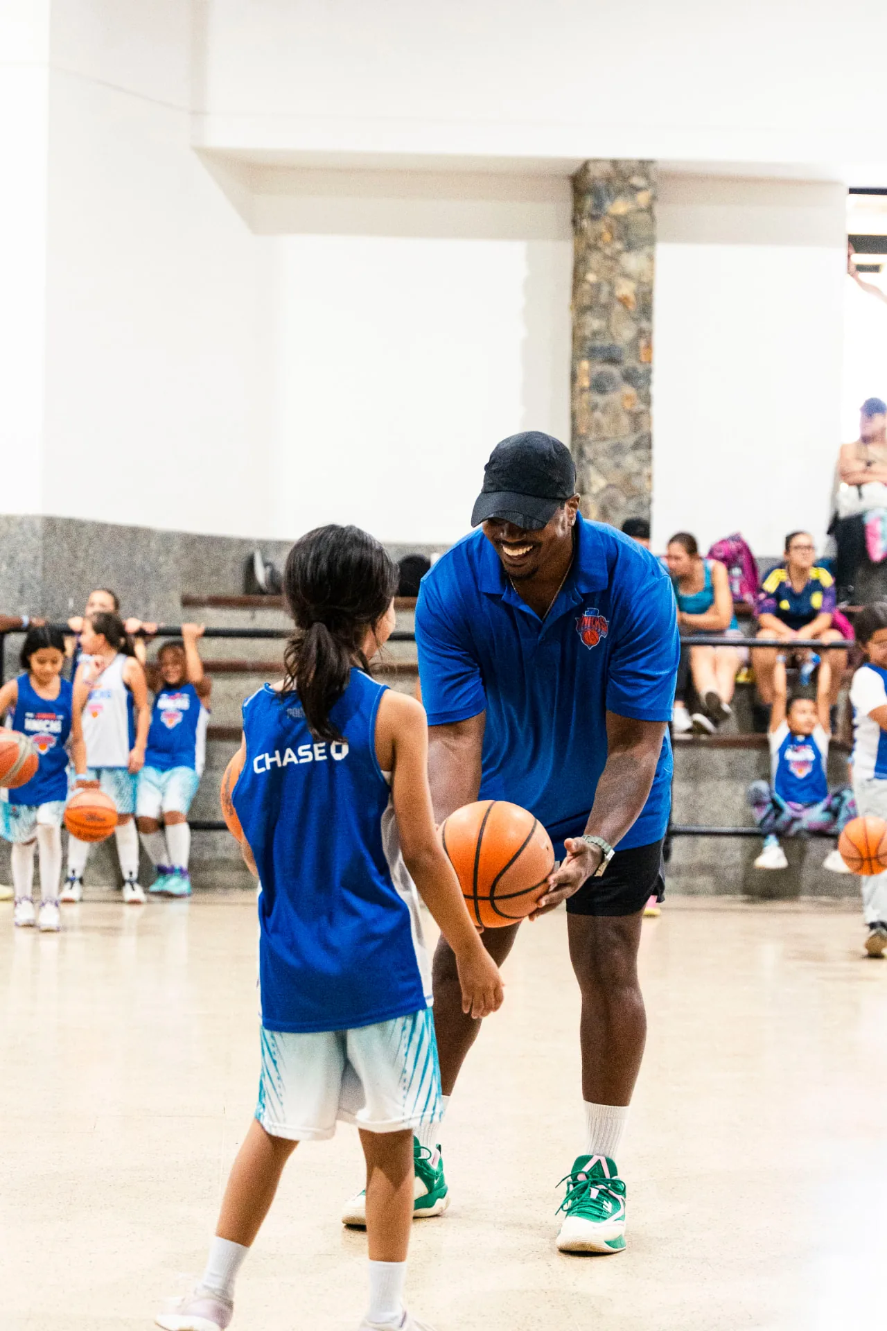 Marcus coaching a young player at a Knicks youth basketball clinic